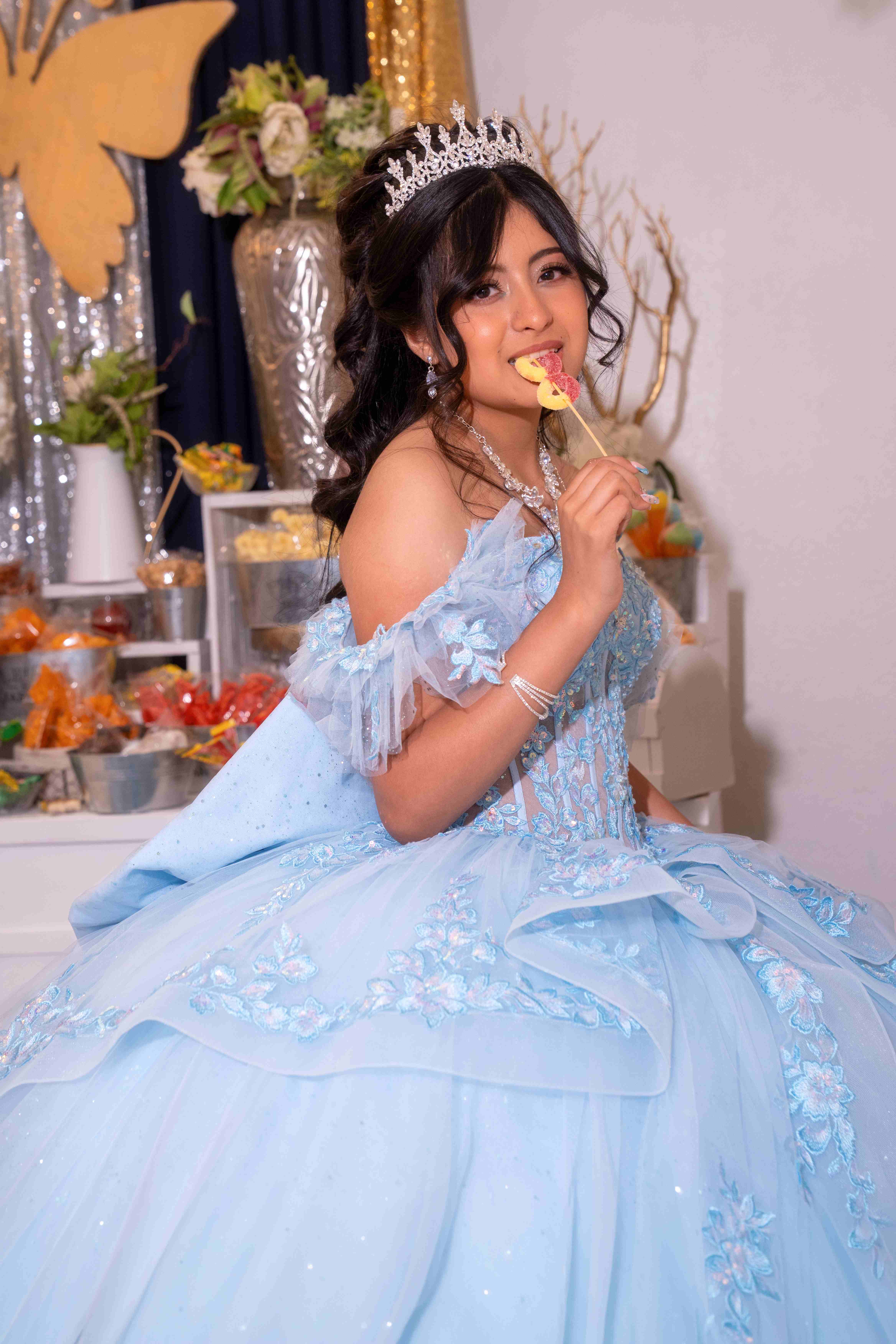 Quinceañera in light blue gown at the candy table
